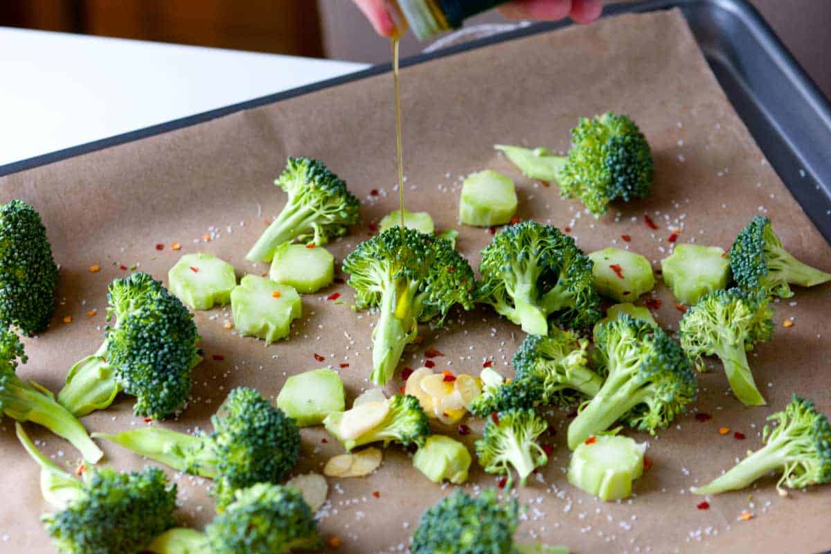 How to Bake Broccoli in the Oven Cheddar Roasted Broccoli: Broccoli on a baking sheet ready to be baked in the oven
