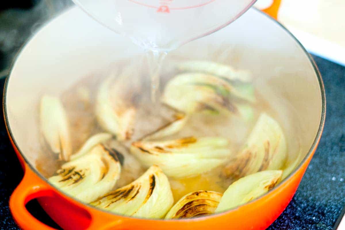 Adding the stock to braise fennel
