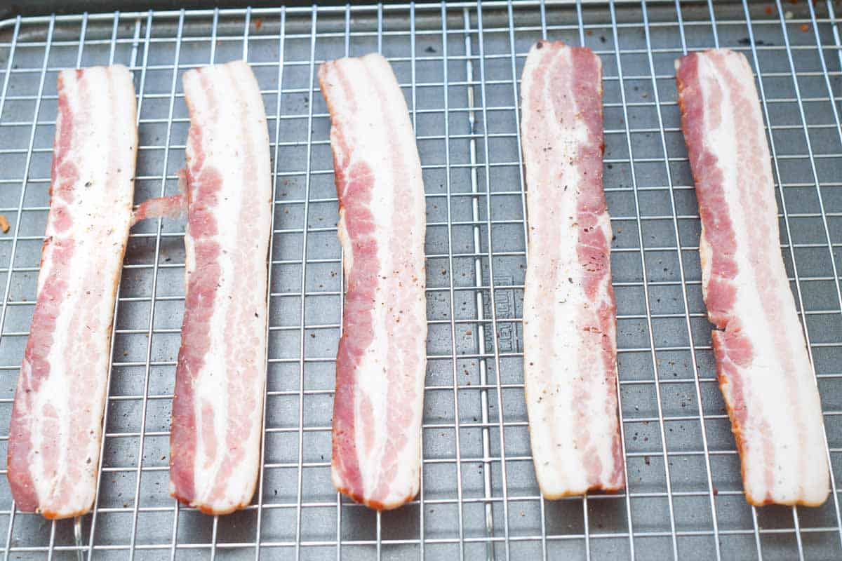 Cooking bacon in the oven using a rimmed baking sheet.