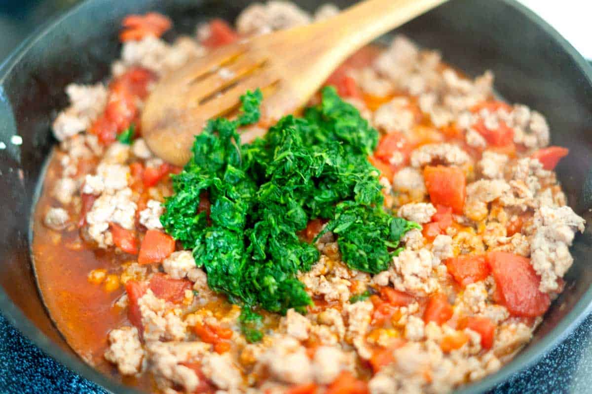 Sausage Stuffed Shells Recipe with Spinach Cooking sausage with tomatoes and spinach for the stuffed shells filling