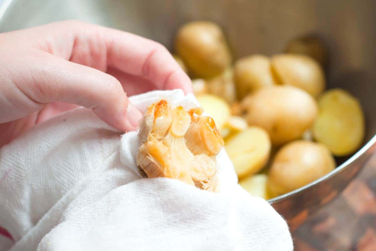 Mashing roasted garlic in the olive oil mashed potatoes