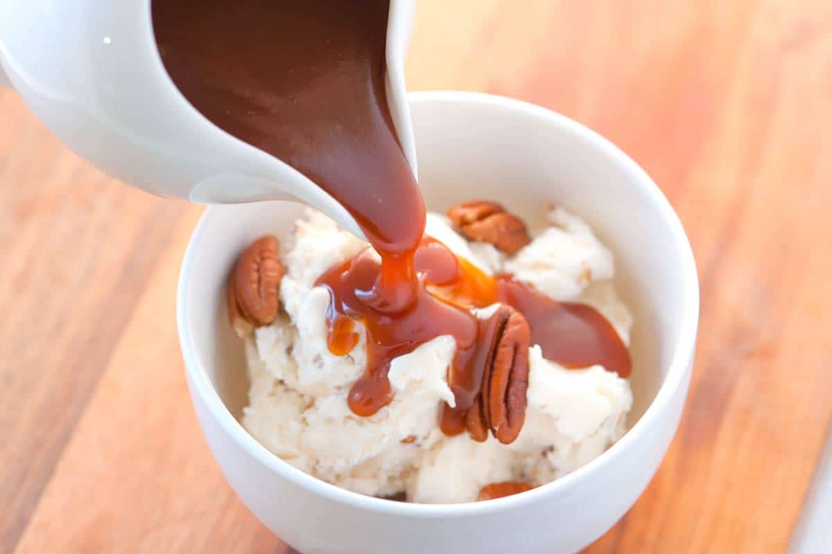 Caramel sauce being poured over ice cream