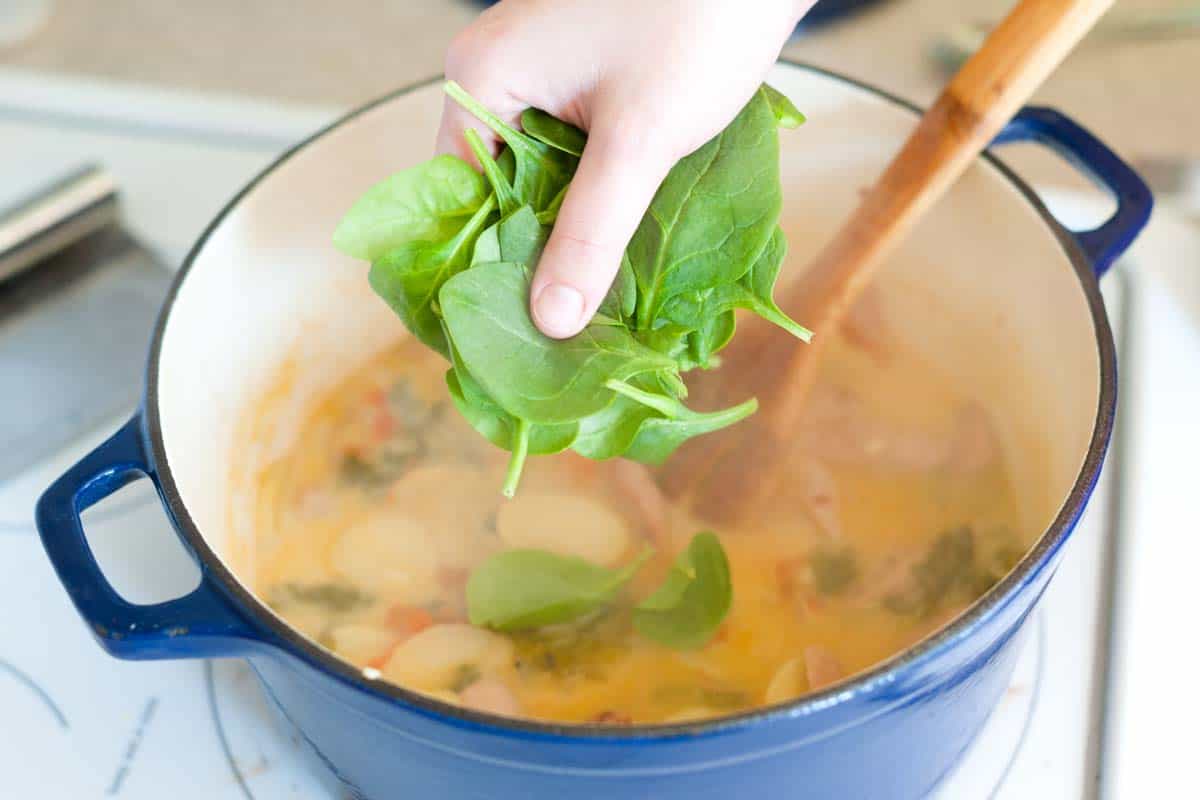 Adding soup ingredients into pot.