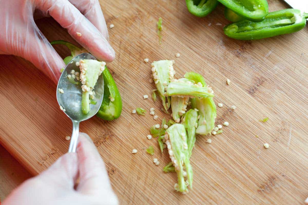 Prepping the jalapeños for poppers by removing the seeds