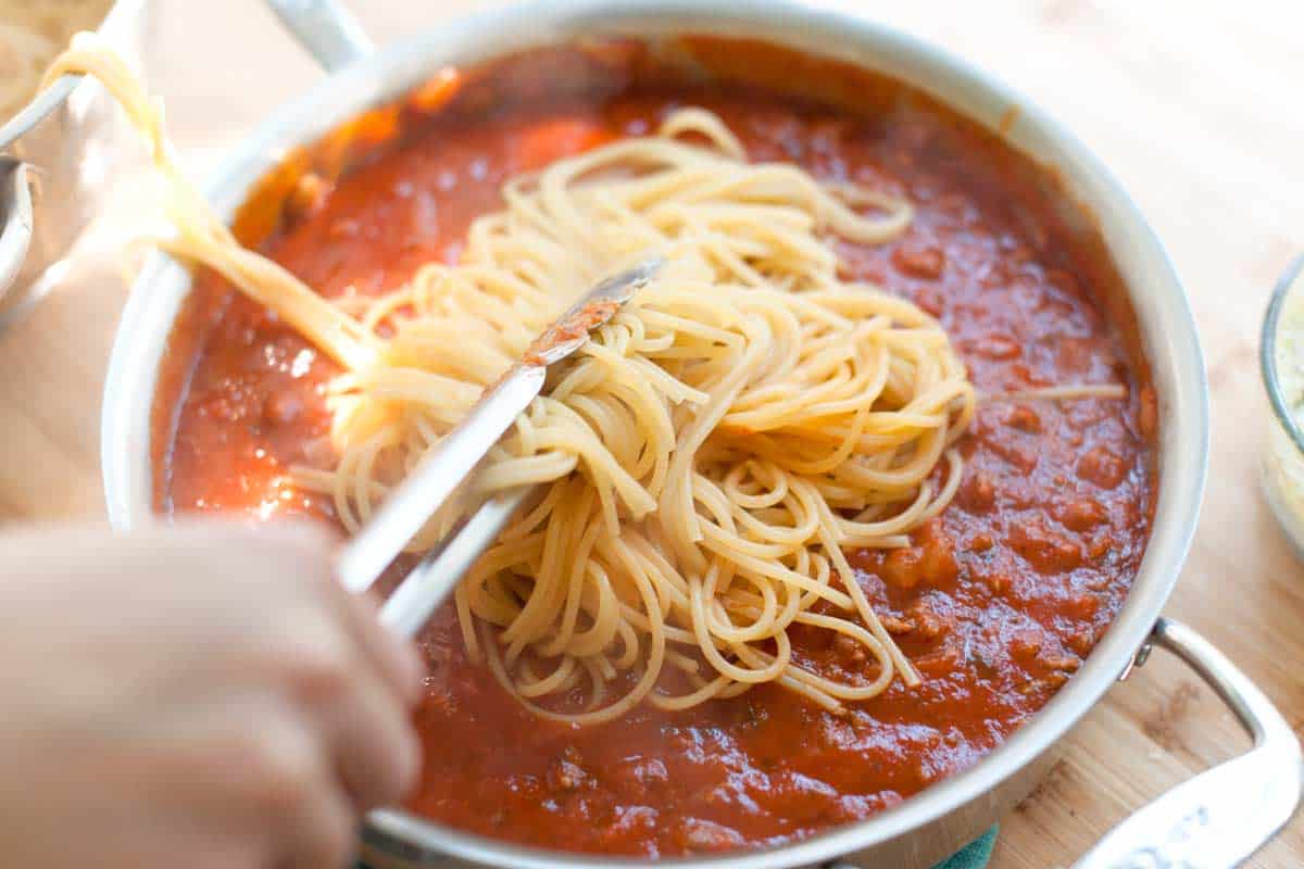 How to Make Baked Spaghetti: Toss spaghetti with marinara sauce