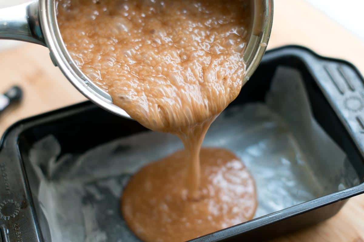How to Make Salted Caramels Recipe Pouring the Caramel Mixture into a lined loaf pan