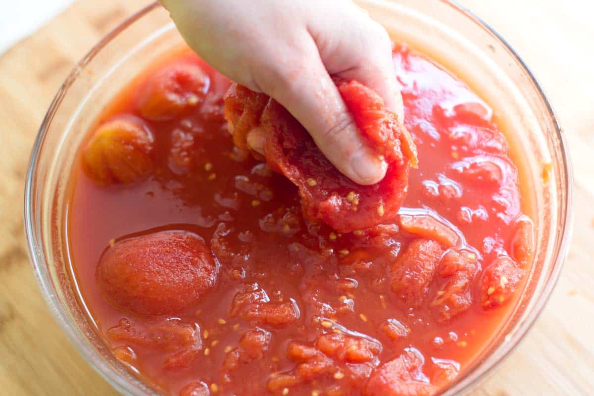 Crushing whole tomatoes for the marinara sauce