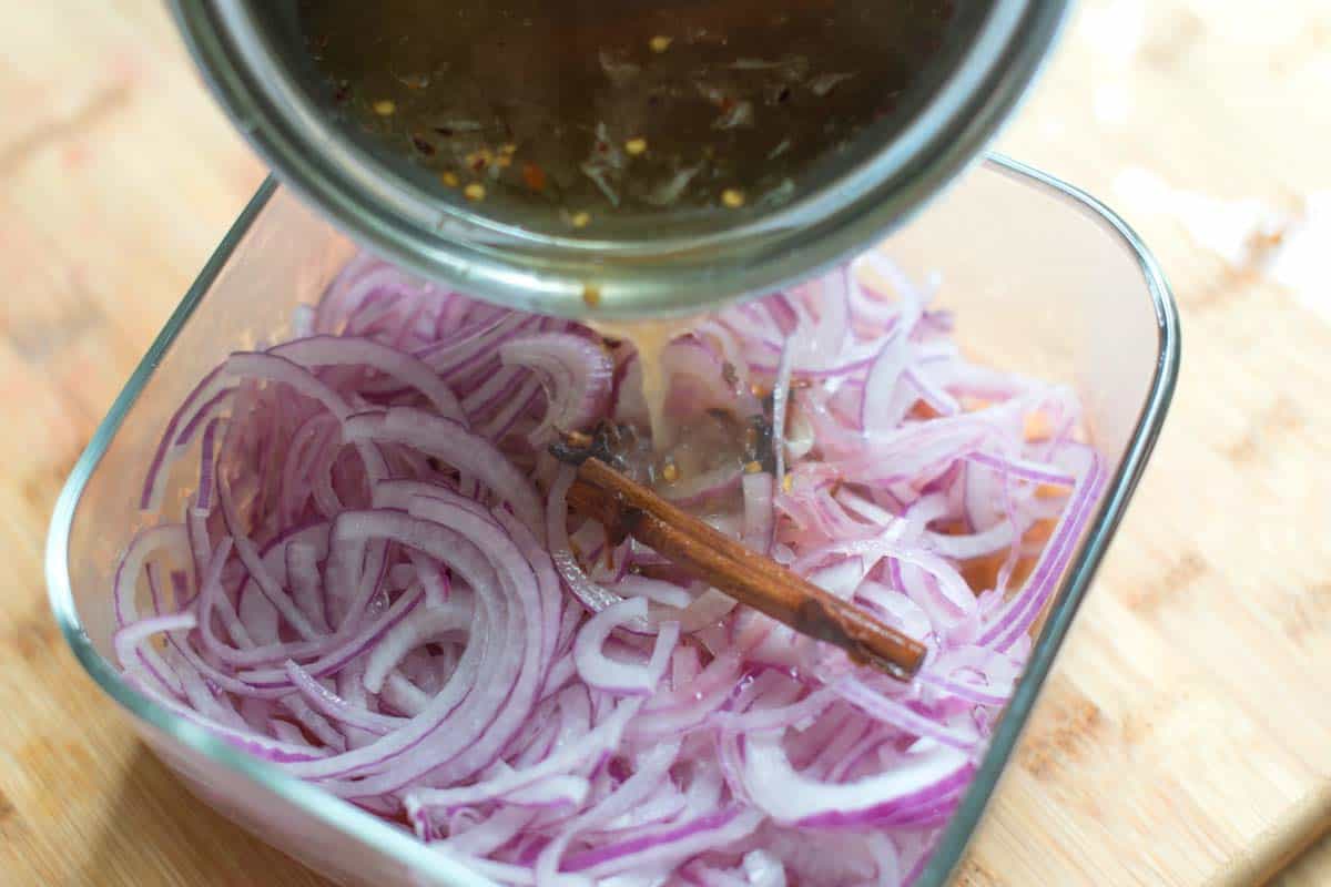 Pouring the brine over sliced red onions.