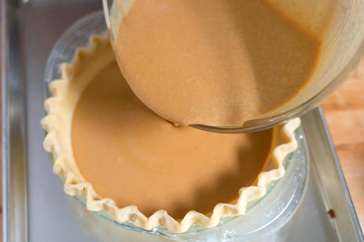 Pouring the pie filling into our crust.
