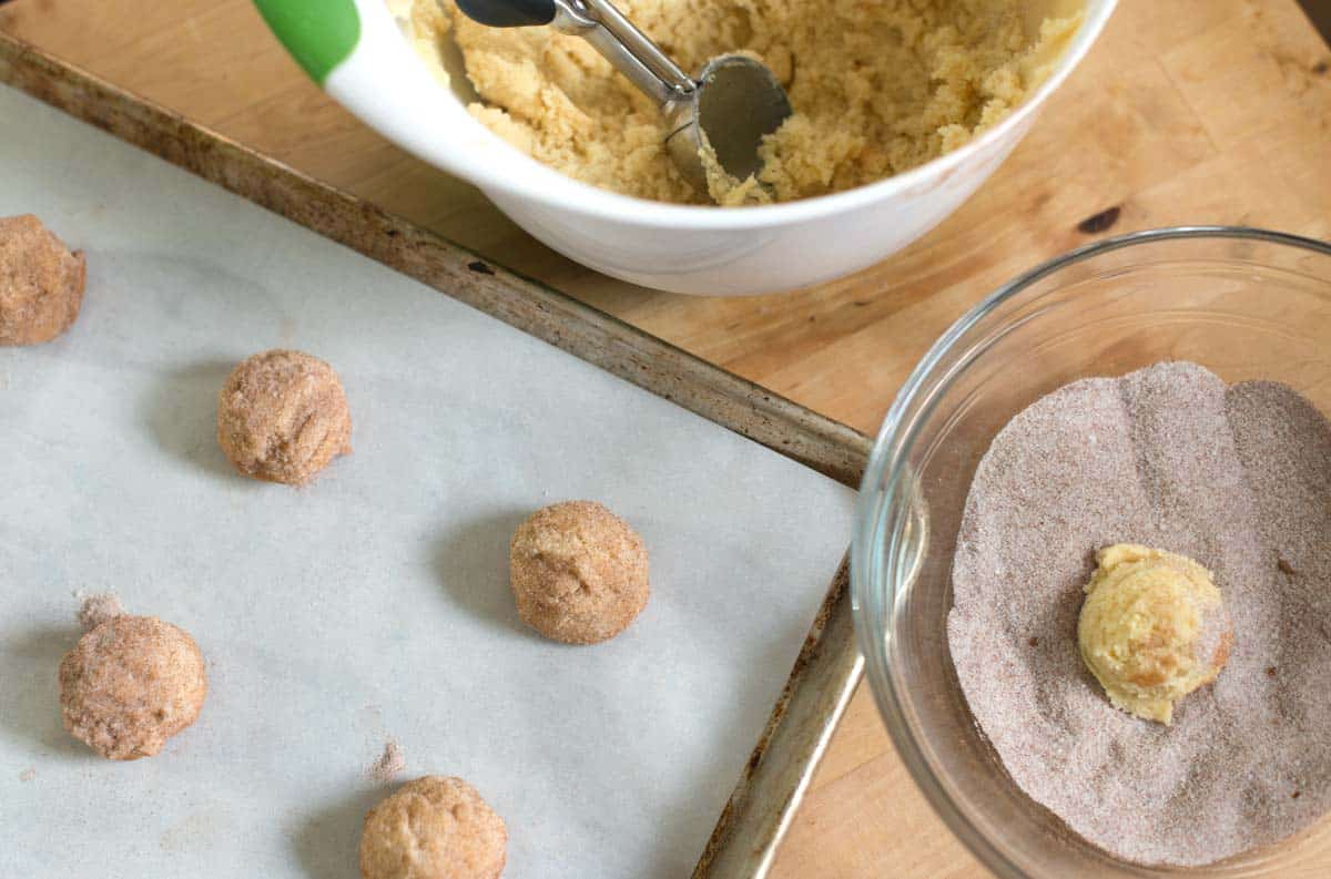 Rolling cookie dough in cinnamon sugar