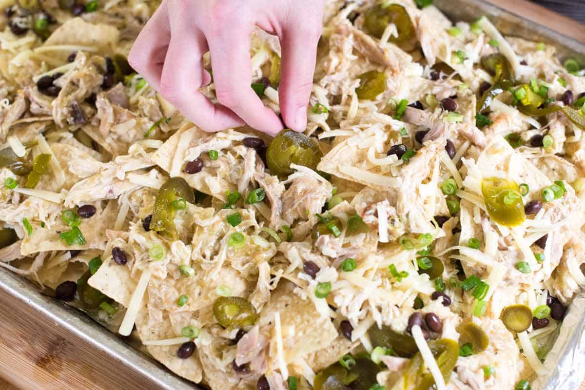 Assembling chicken nachoso n a sheet pan