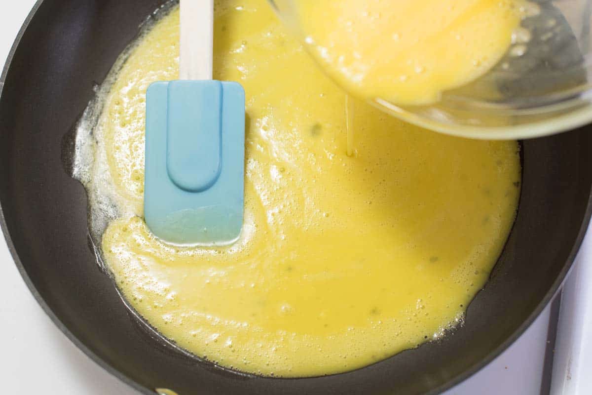 Scrambled egg mixture pouring into pan