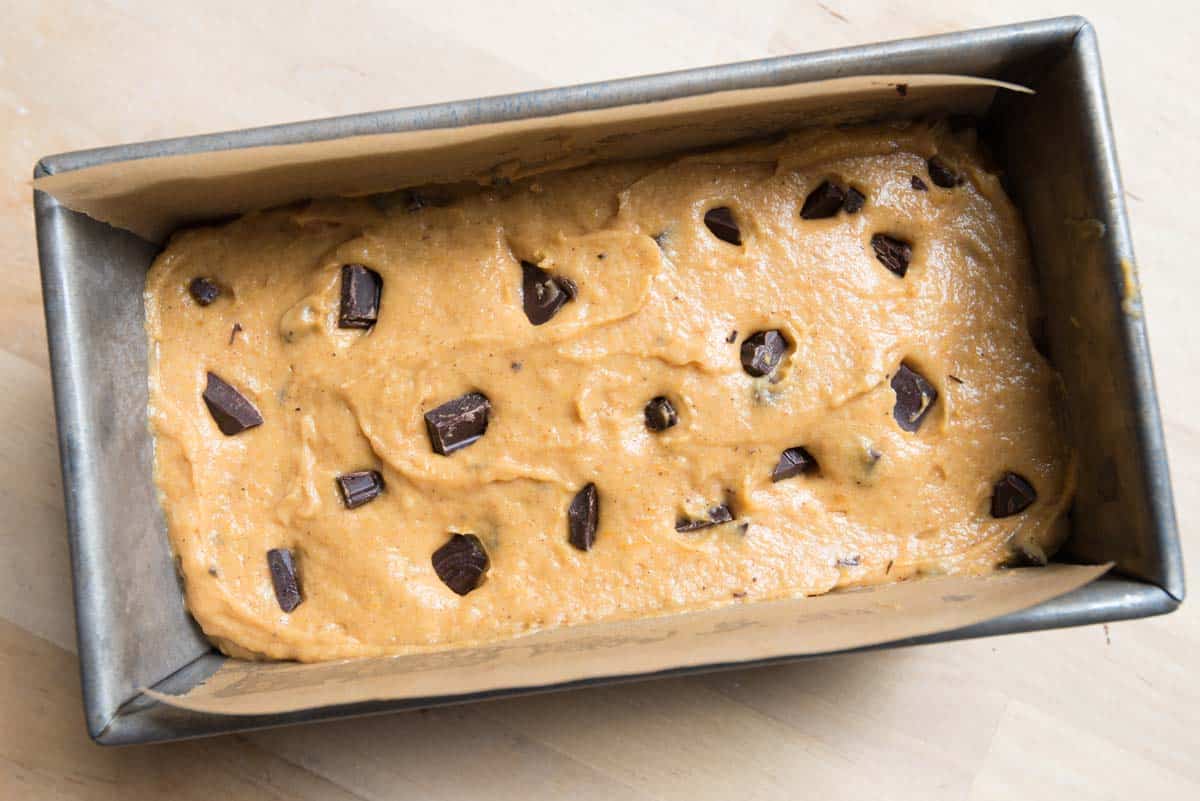 Adding chocolate chips to the top of the pumpkin loaf