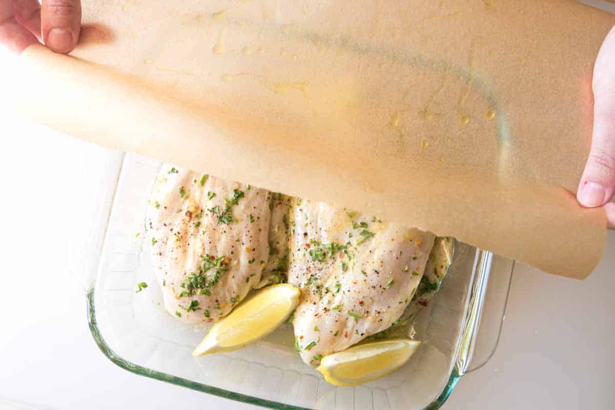 Loosely covering the chicken before baking.