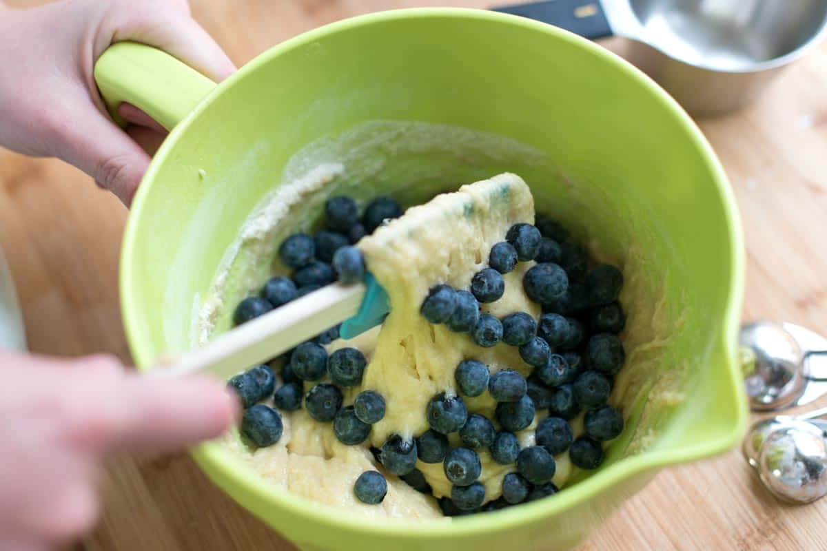 Mixing our easy blueberry muffin batter with blueberries