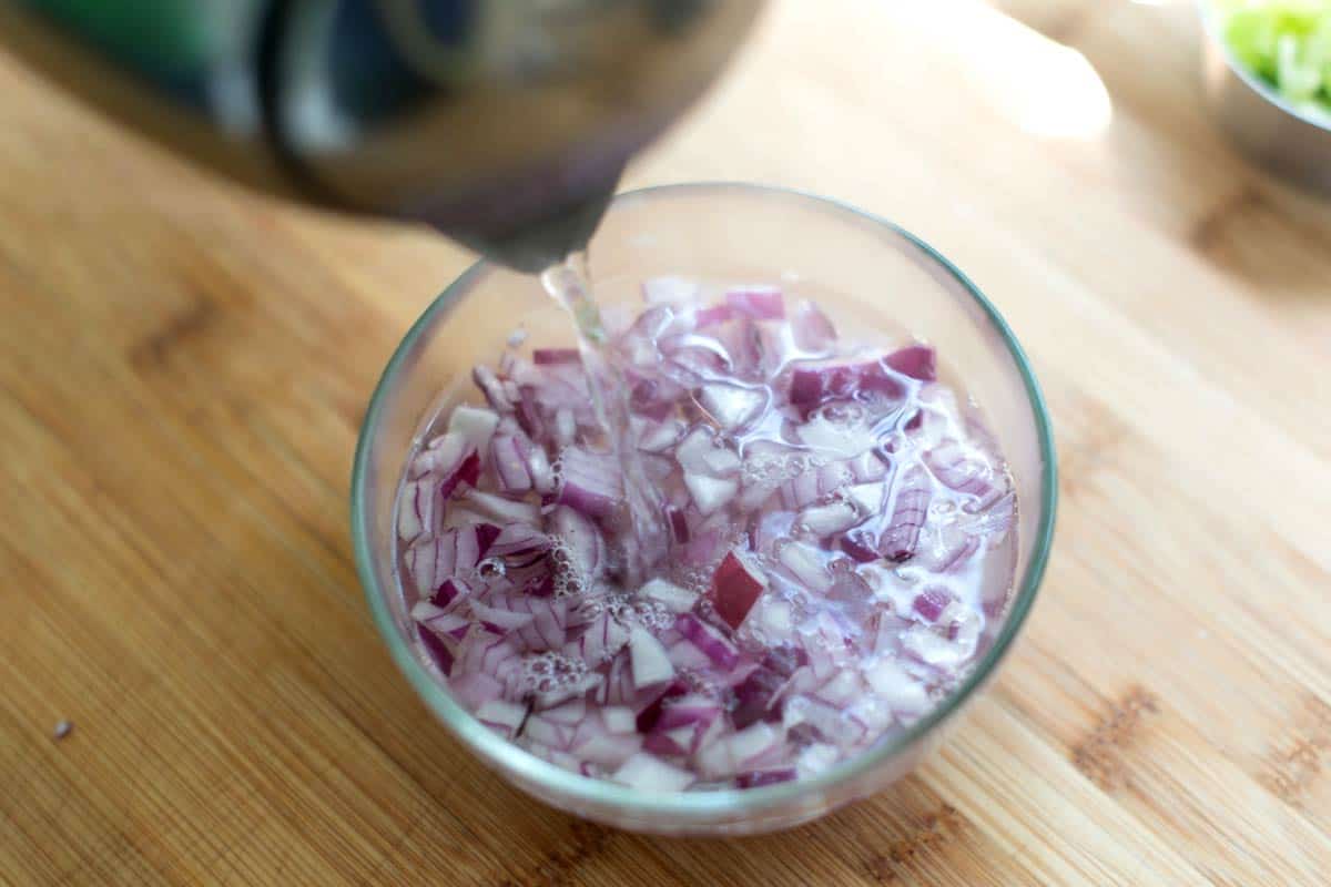 Deflaming the onions to tone down the raw flavor of the onions in the salad.