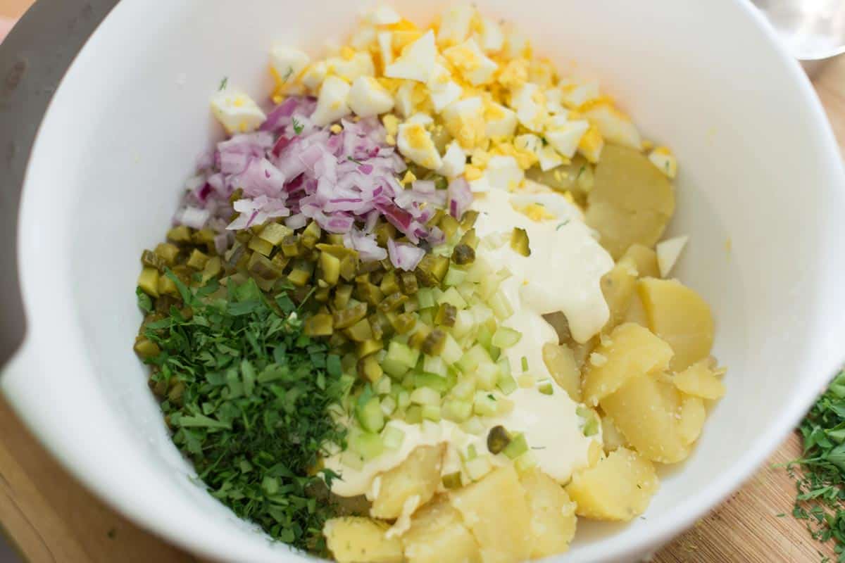potato salad ingredients in a bowl ready to be mixed