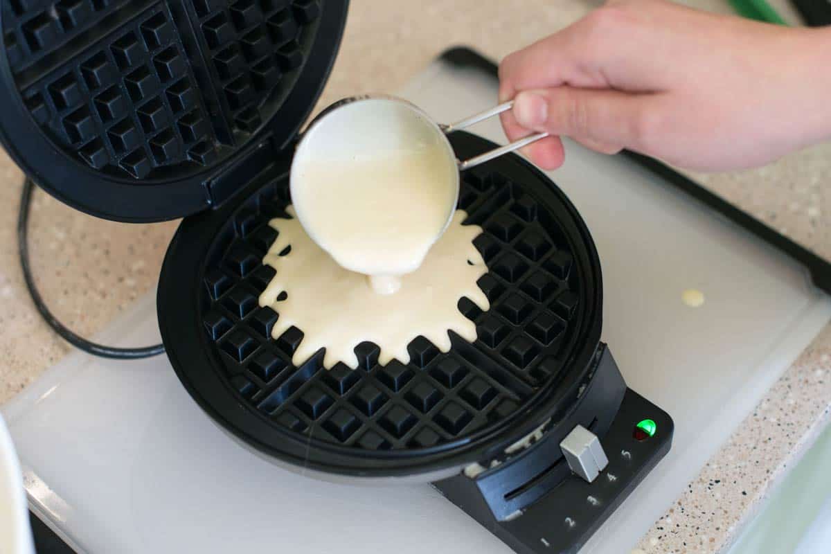 Pouring waffle batter into a classic waffle iron