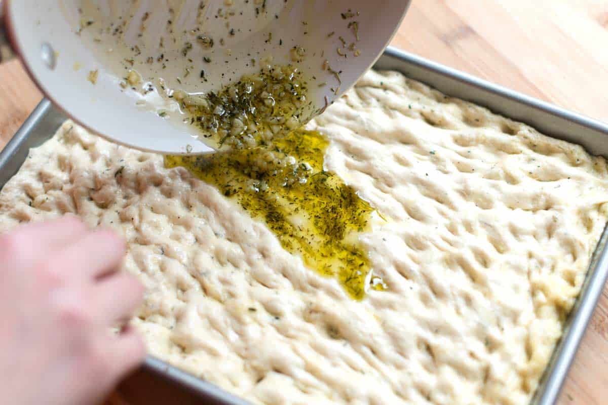 Adding olive oil to the top of the dough, almost ready to bake.