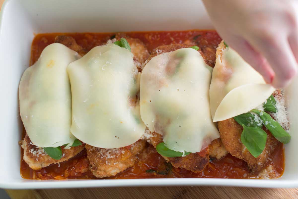 Adding parmesan cheese and provolone cheese to the chicken before baking