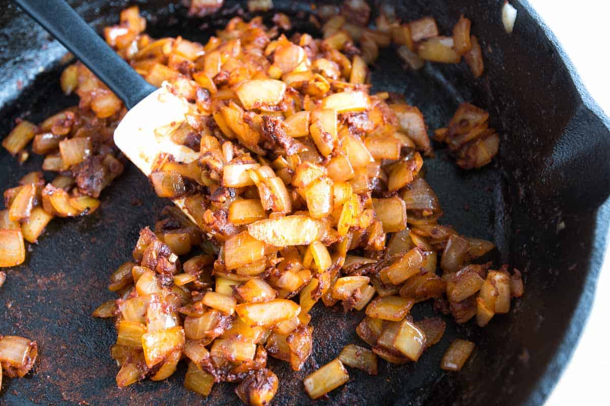 sautéing onions and spices in a skillet