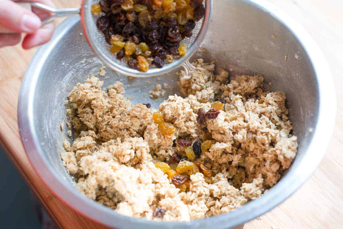 Adding the plumped raisins to the cookie batter