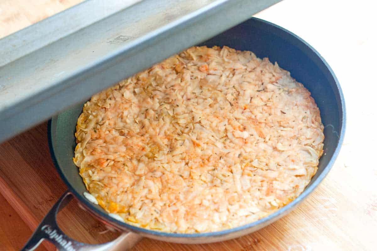 Flipping the potato pancake using a baking sheet