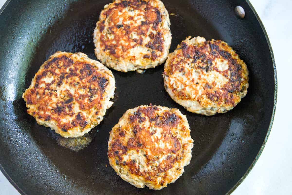 Turkey burger patties cooking in skillet