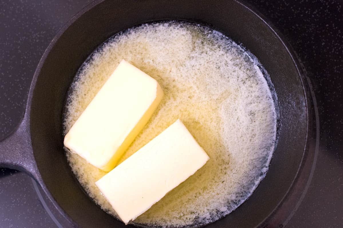 Melting butter in a skillet over low heat.