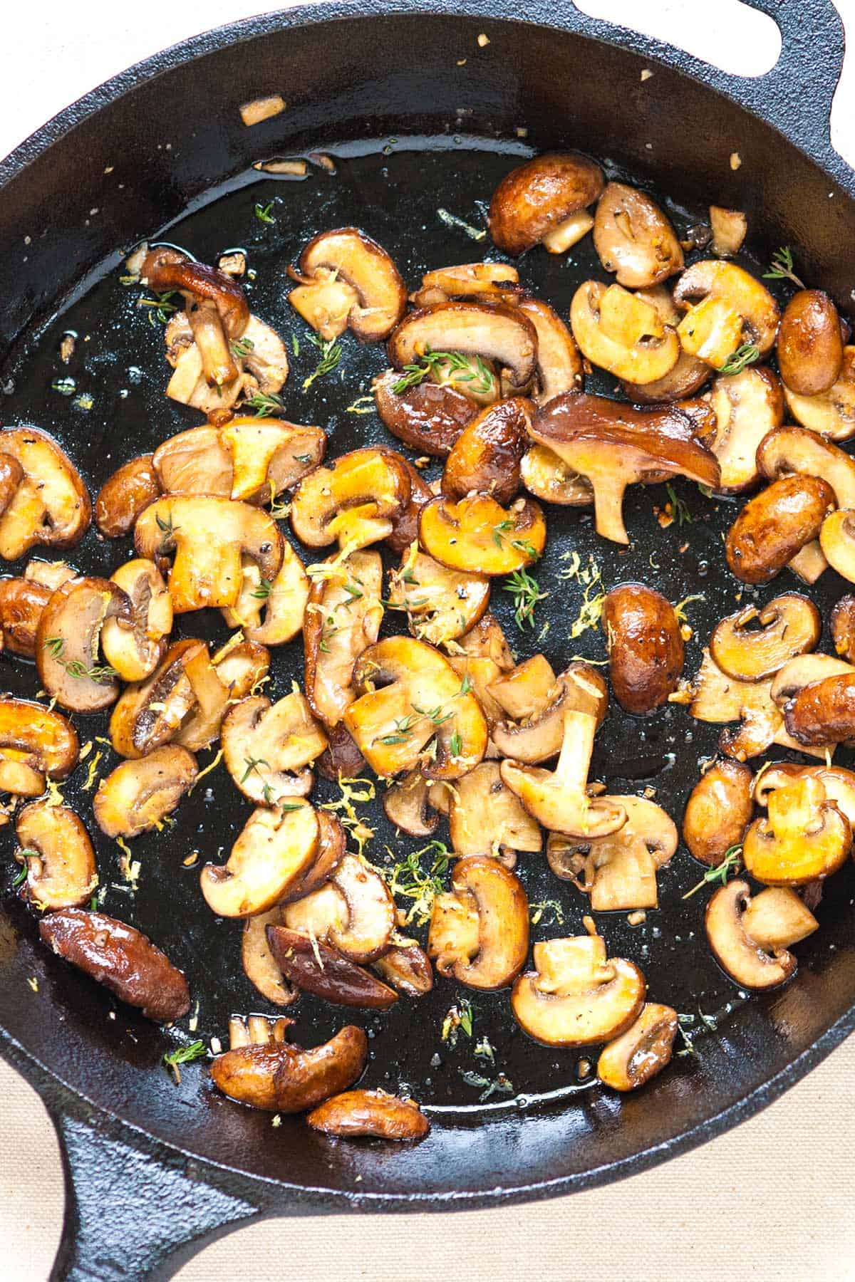 Golden brown mushrooms in cast iron skillet