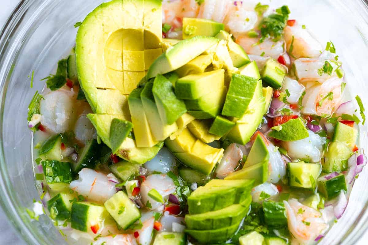 Adding avocado to the shrimp just before serving.