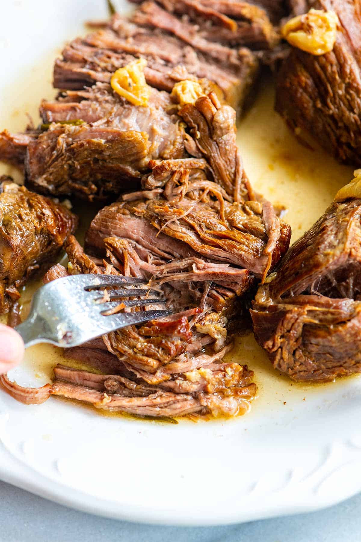 Fork pulling apart tender Instant Pot pot roast.