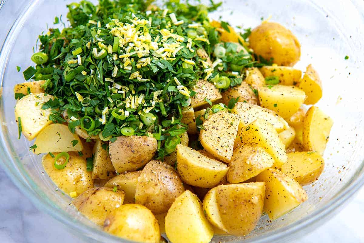 Adding herbs to potato salad 