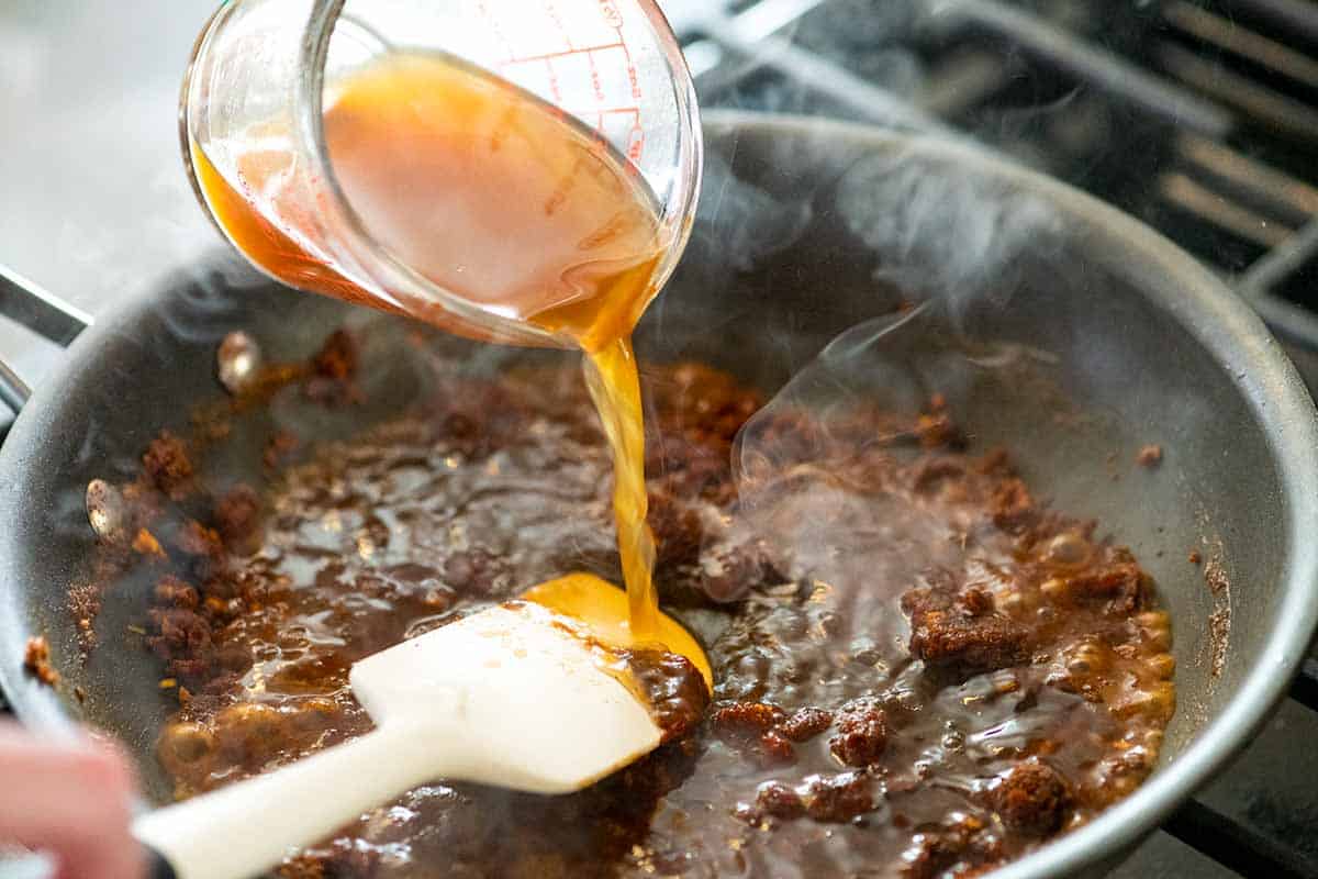 Adding broth to the spices