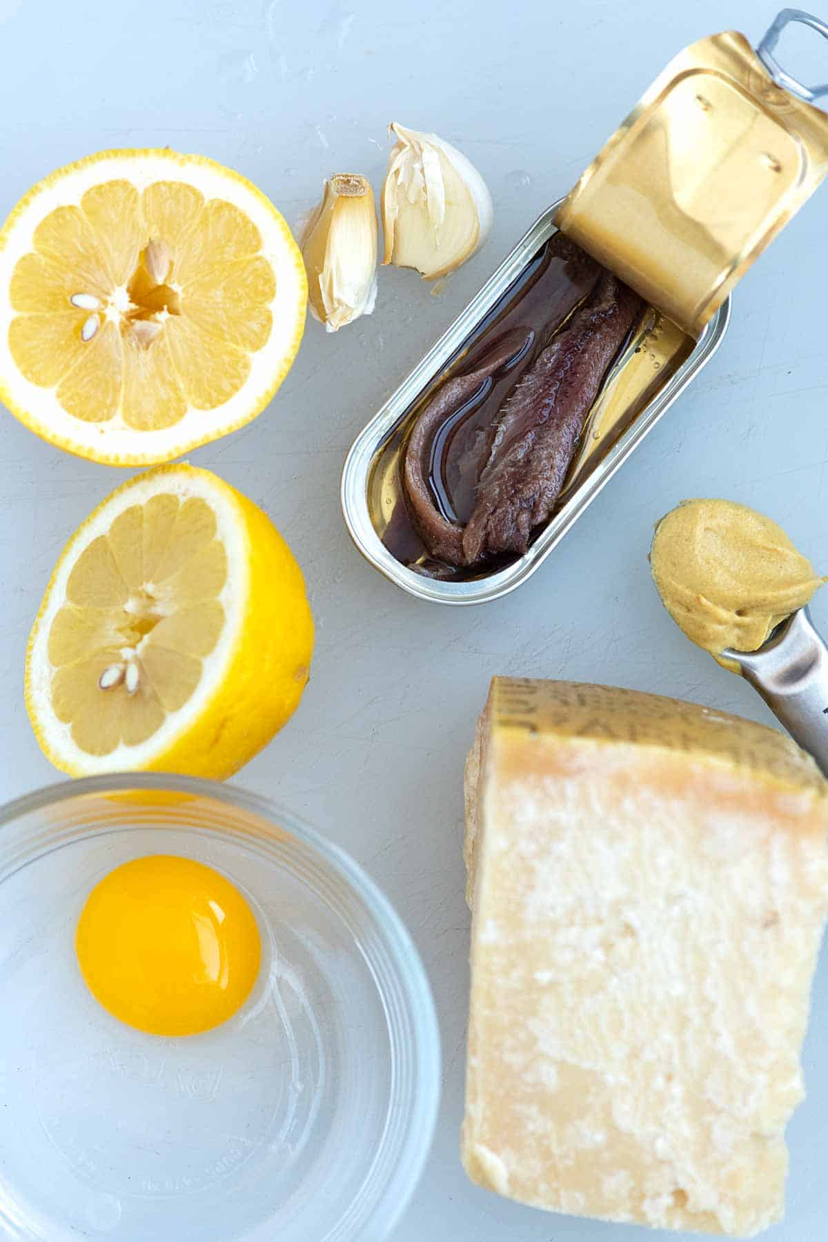 Caesar Dressing Ingredients (lemon, garlic, anchovies, mustard, parmesan cheese and egg yolk)