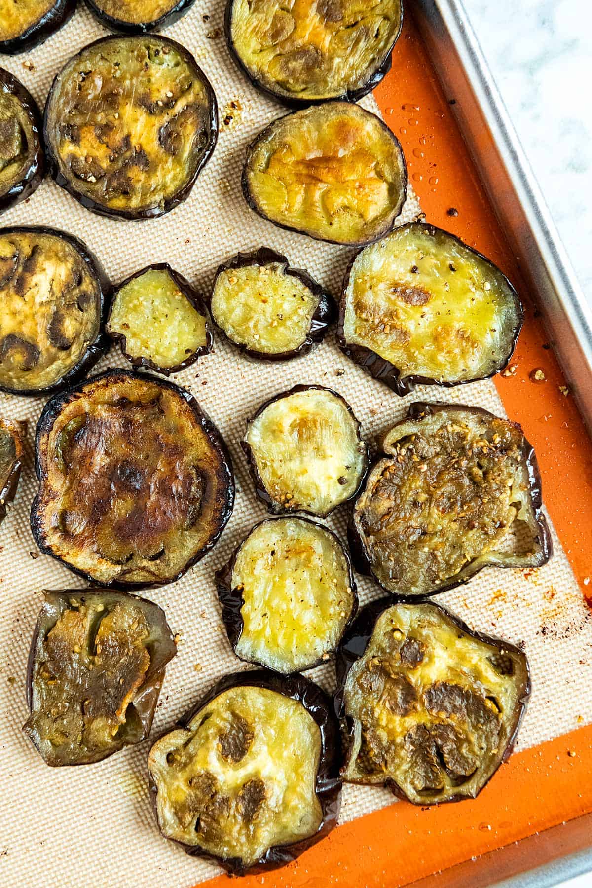 Roasted eggplant slices on baking sheet ready for baked eggplant parmesan