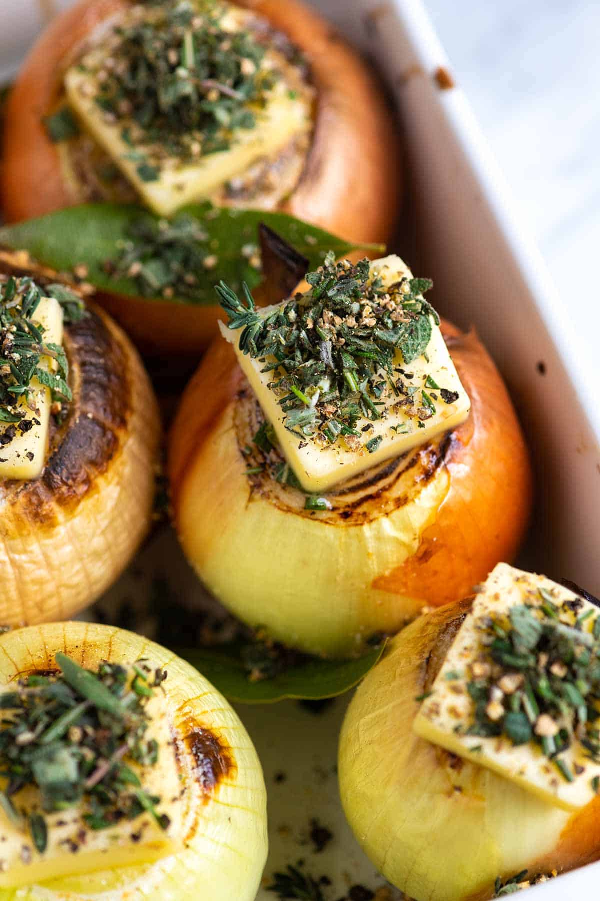 Onions with butter and herbs ready to be baked in the oven.