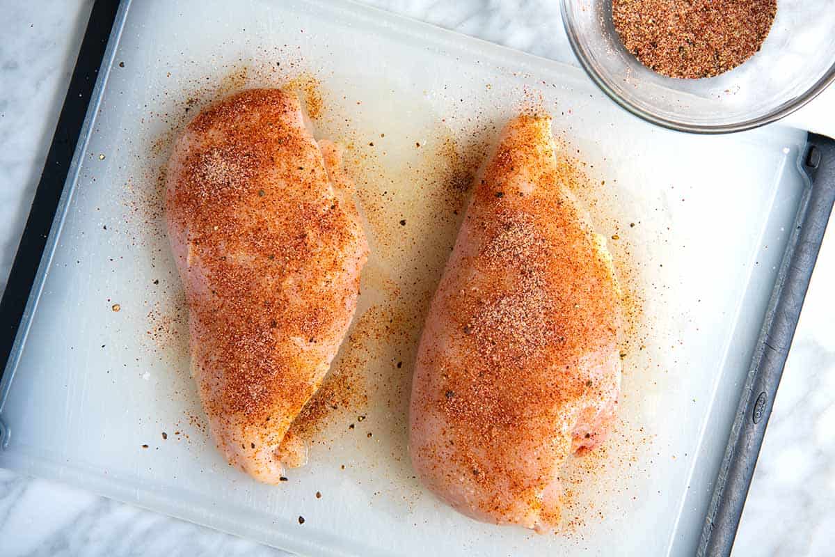 Seasoning the chicken breasts before cooking them in a skillet