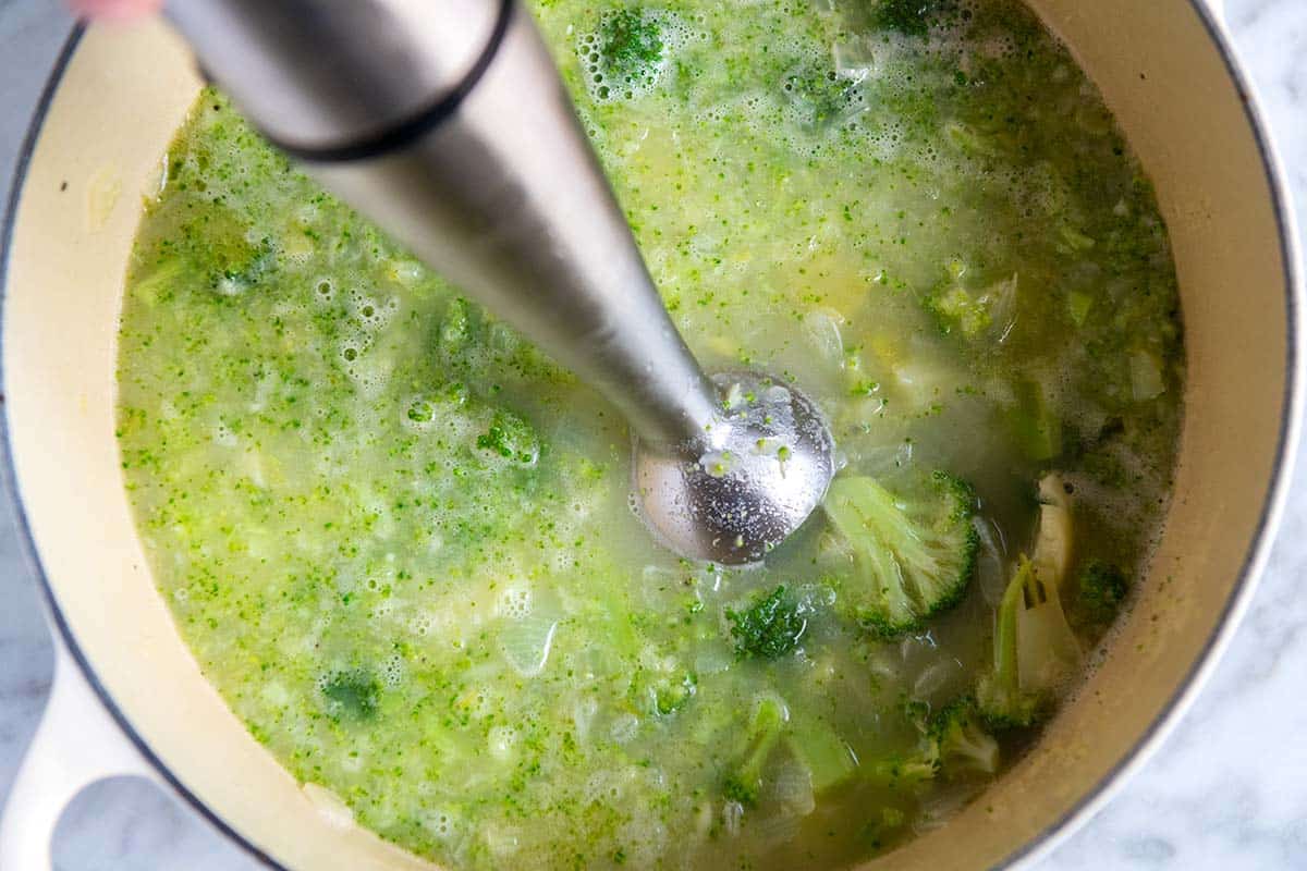 Blending broccoli cheddar soup ingredients with an immersion blender
