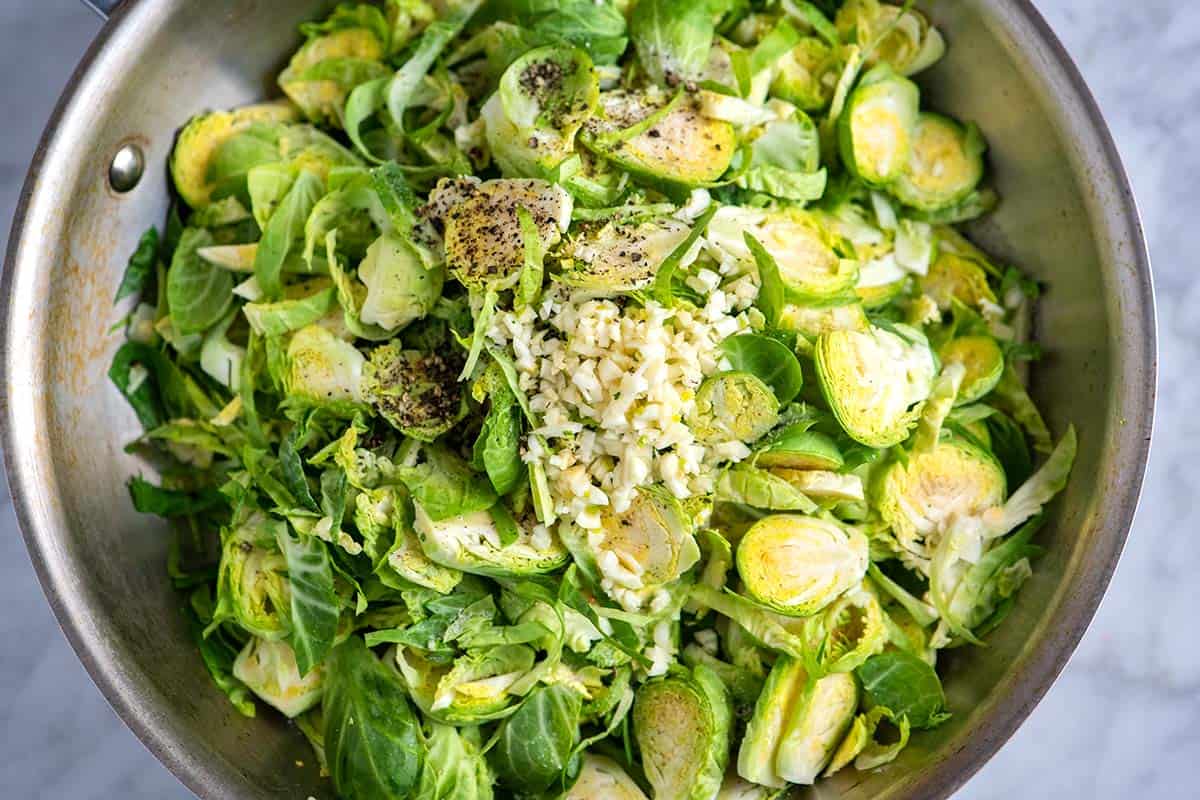 Cooking shredded Brussels sprouts with garlic and butter.