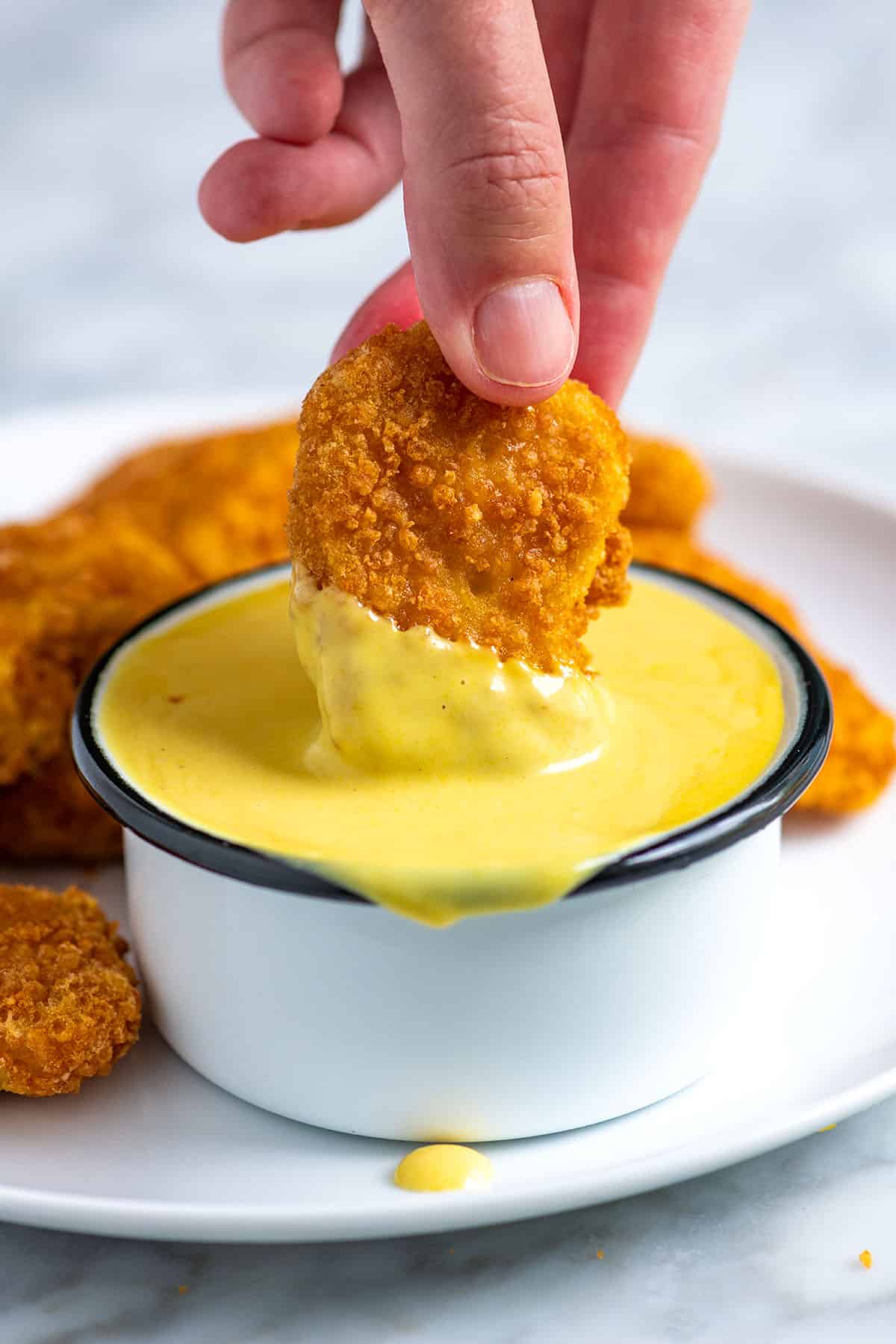 Dipping chicken nuggets into homemade honey mustard sauce