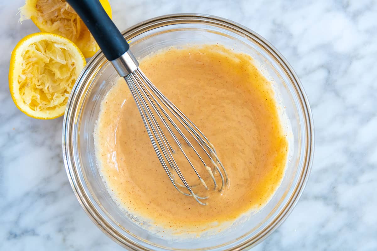 Whisking the tahini dressing ingredients together in a bowl