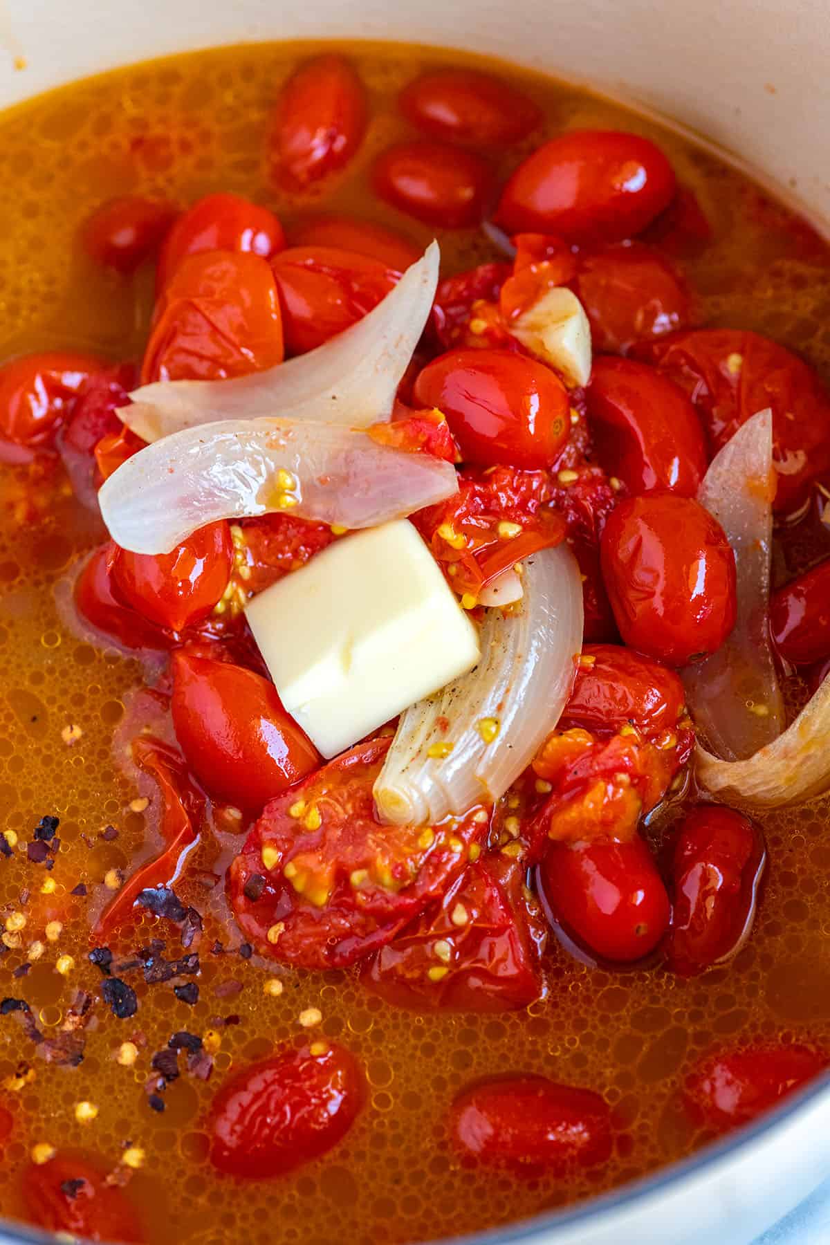 Roasted tomatoes with broth in a soup pot.