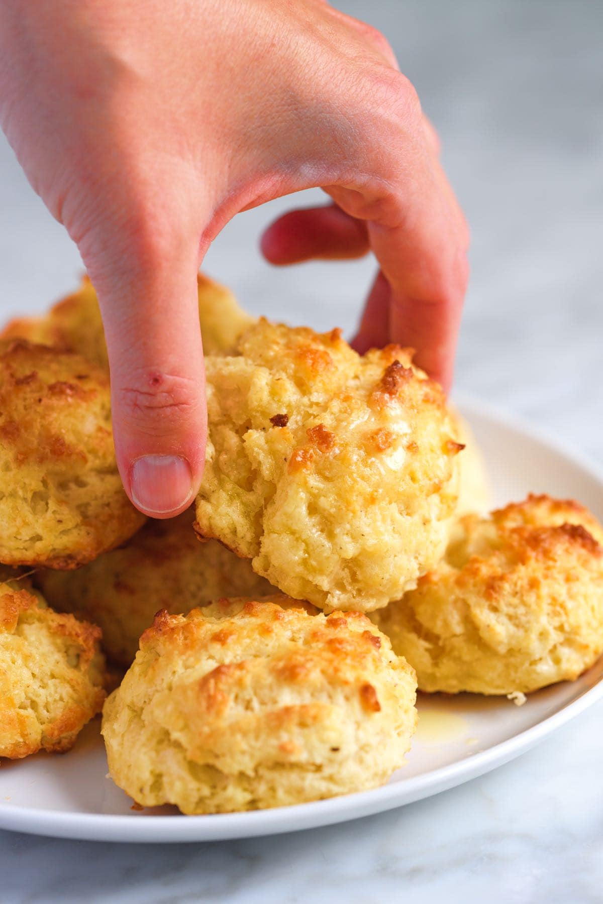 Picking up a cheese biscuit.