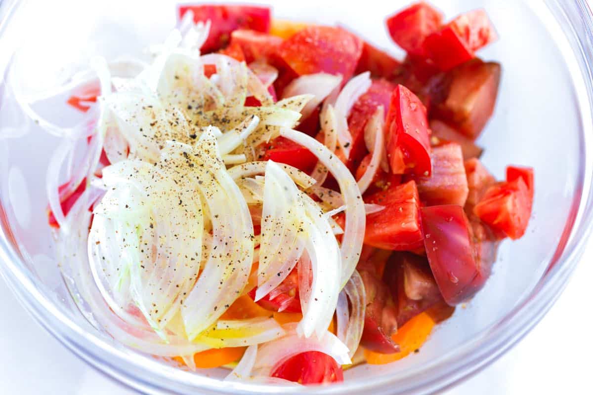 How to Make Panzanella Salad: Marinating tomatoes with onions, salt, sugar, vinegar, and olive oil for panzanella salad