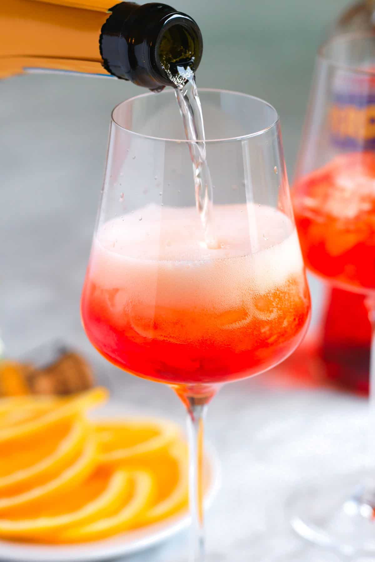 Pouring prosecco into a glass with Aperol for an Aperol Spritz