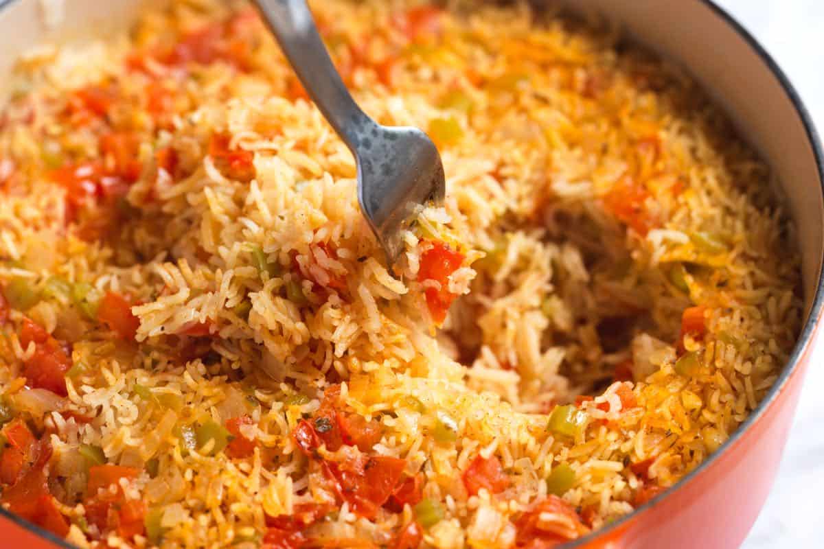 Fluffing cooked Mexican rice with a fork before serving