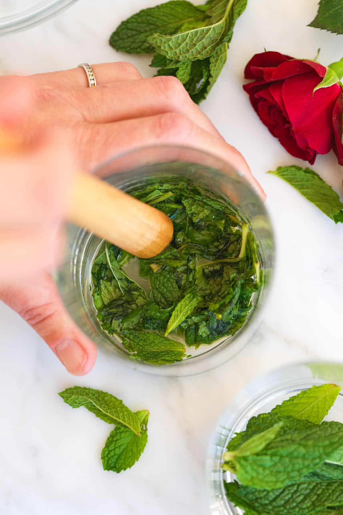 Muddling fresh mint with simple syrup
