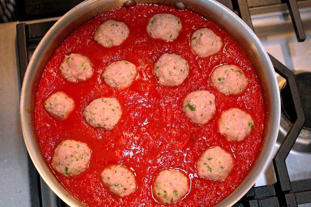 simmering meatballs in sauce on the stovetop