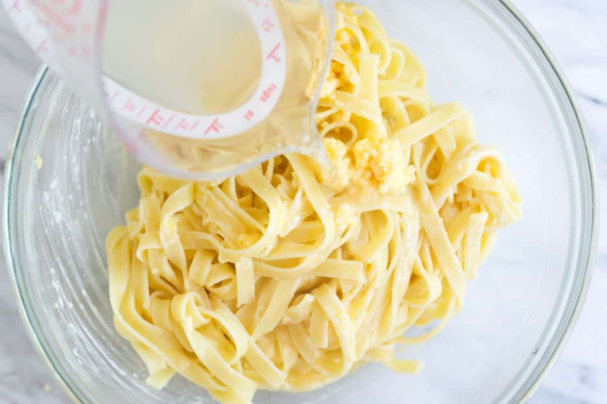 Adding the pasta cooking water to make the Alfredo sauce